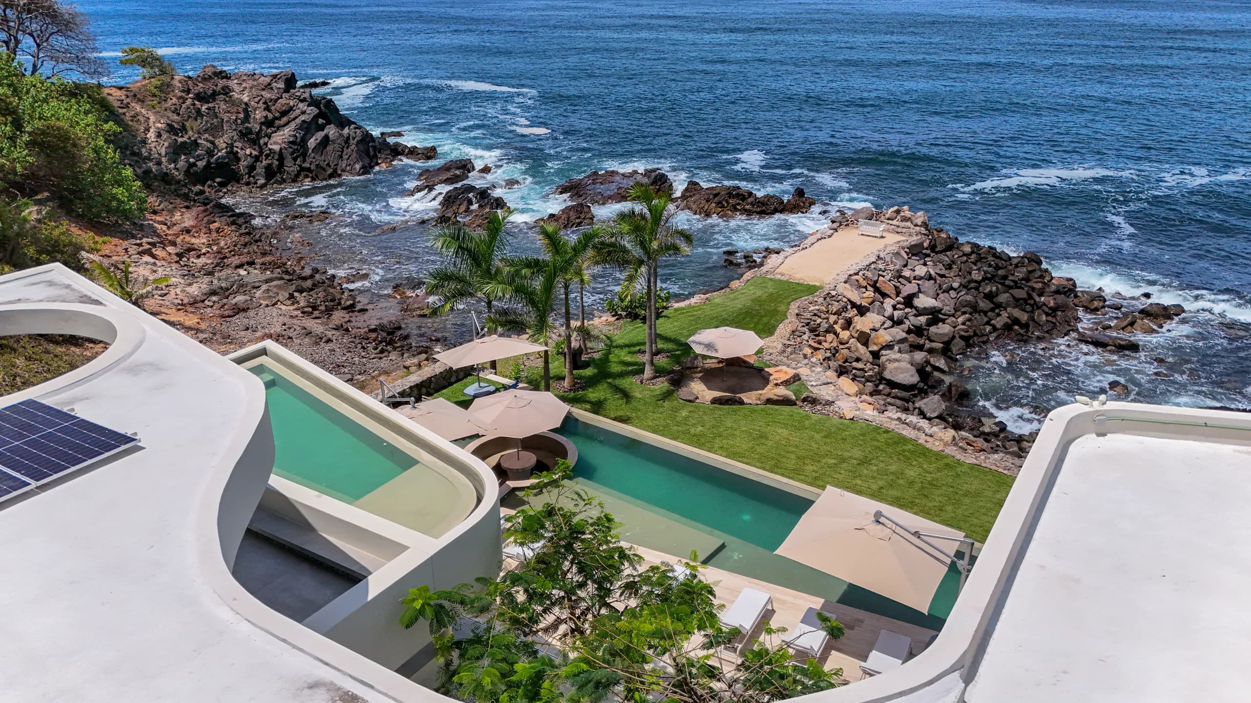 Espacios interiores de concepto abierto diseñados para integrarse naturalmente con la terraza, las vistas al océano y el entorno tropical.