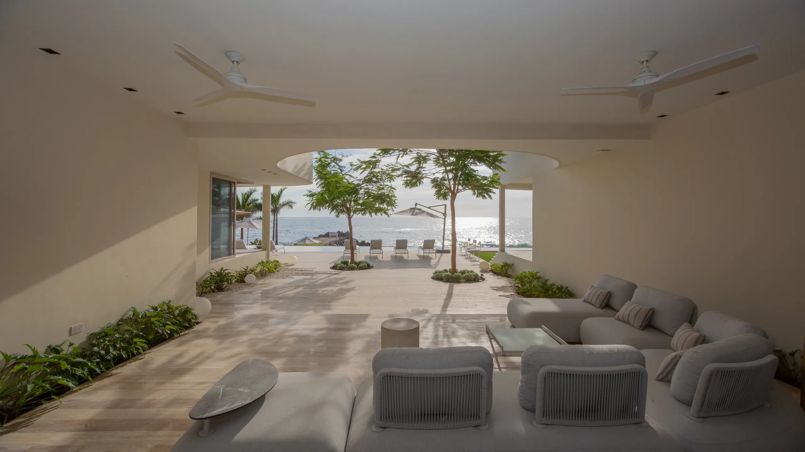 Espacios interiores de concepto abierto diseñados para integrarse naturalmente con la terraza, las vistas al océano y el entorno tropical.