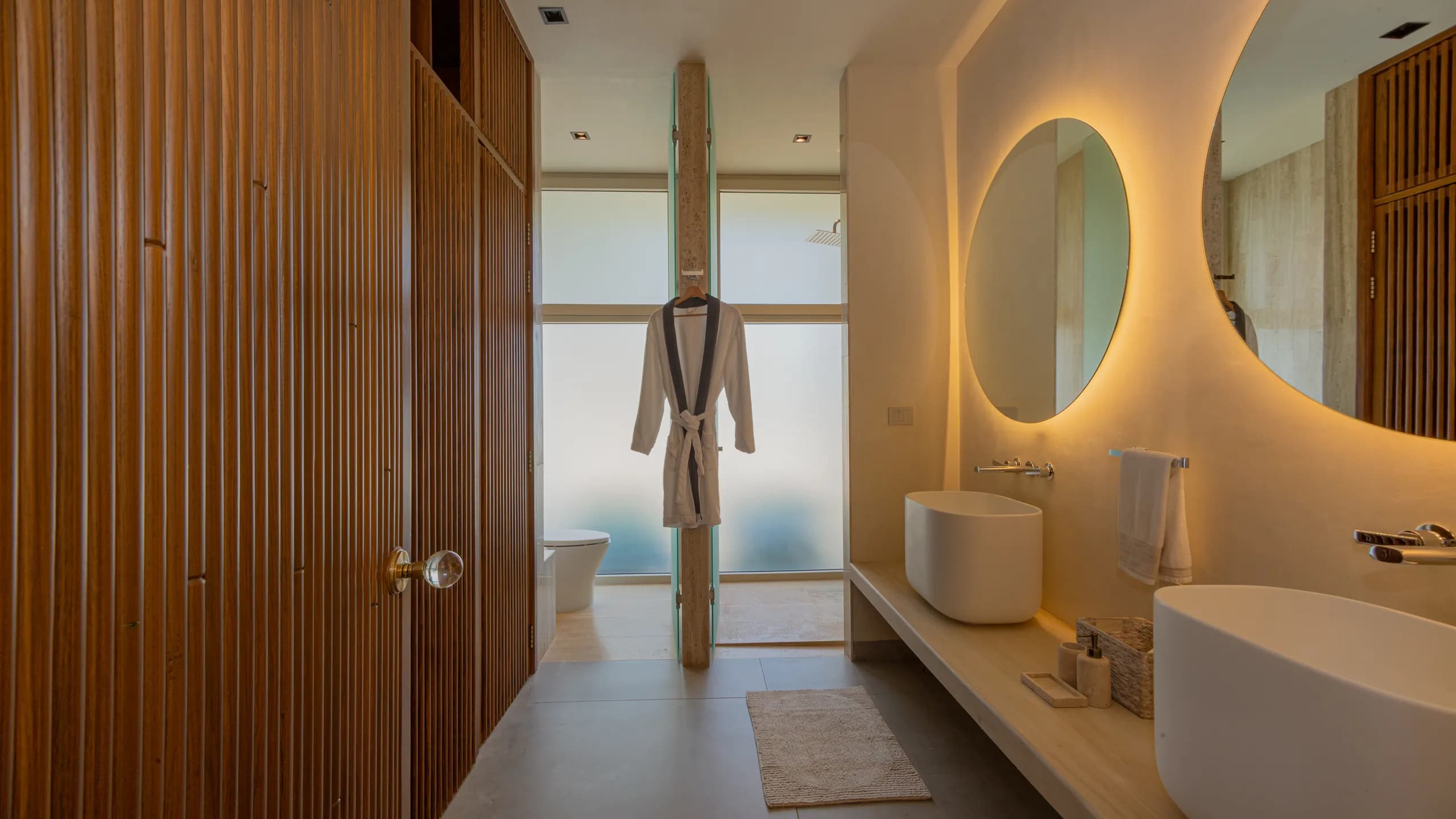 Baño inspirado en un ambiente tipo spa, con texturas naturales, iluminación cálida y acabados contemporáneos.