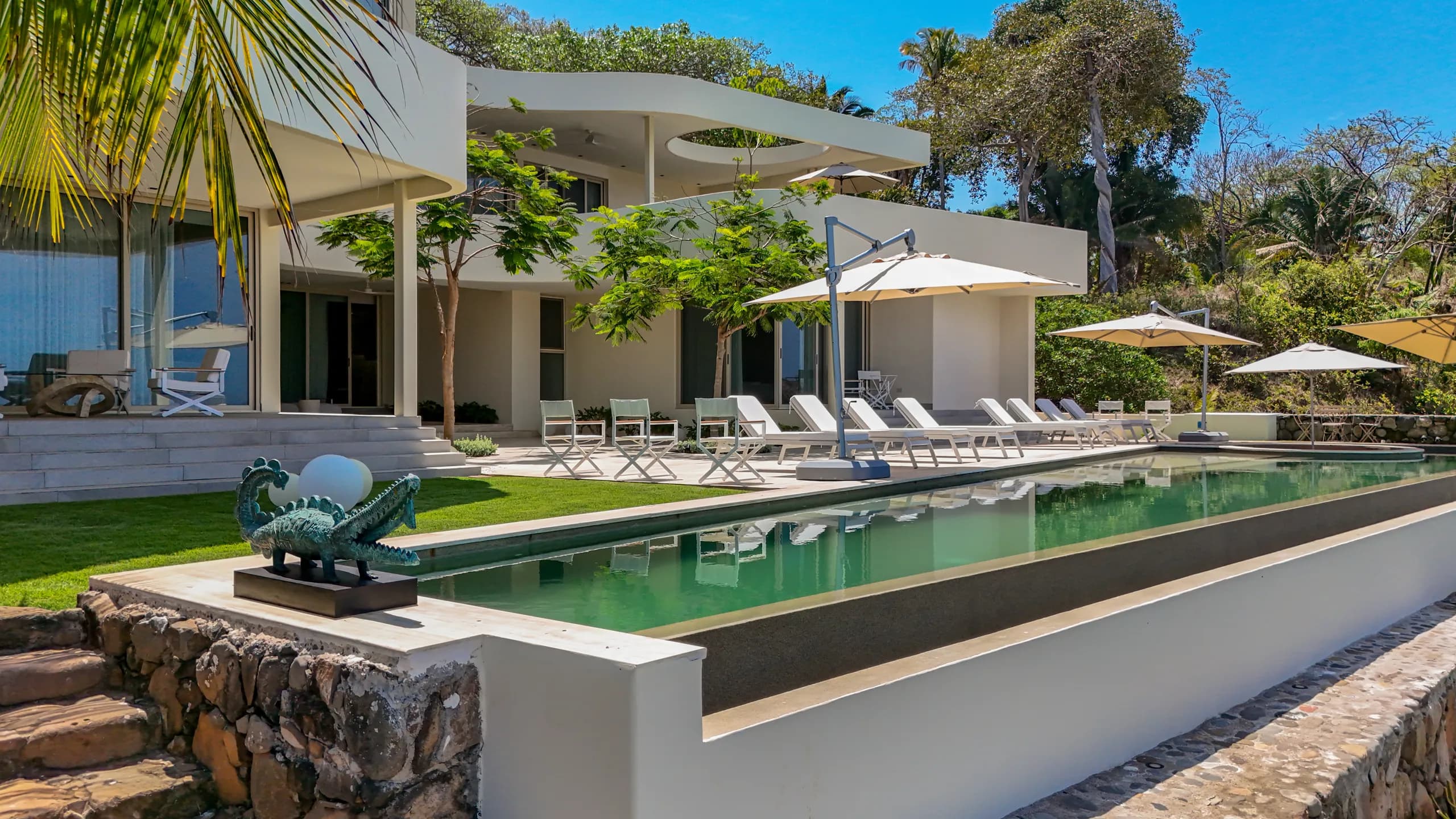 El diseño exterior minimalista y las amenidades inspiradas en resorts crean una residencia enfocada en privacidad y sofisticación costera.