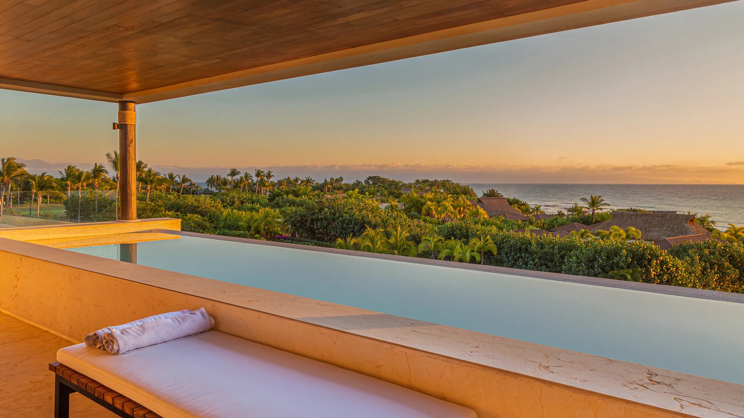 Infinity-edge pool overlooking tropical gardens and ocean views from a private luxury residence
